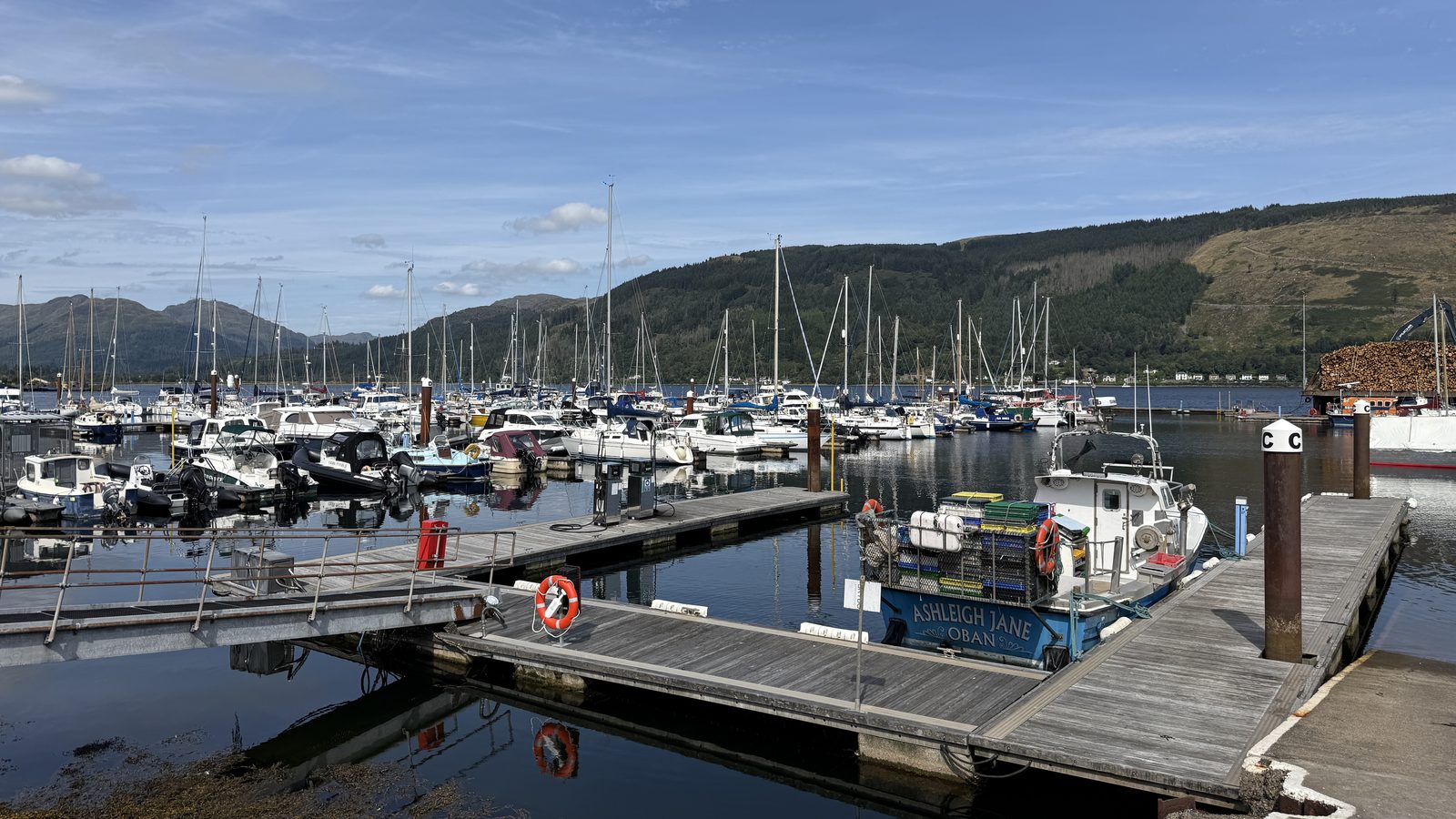 Floating pontoon berths and finger walkways at a Scottish marina, with yachts, motor boats and RIBs alongside