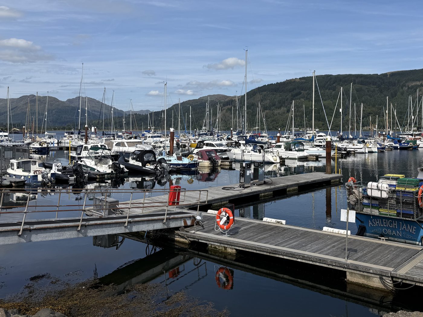 Floating pontoon berths and finger walkways at a Scottish marina, with yachts, motor boats and RIBs alongside